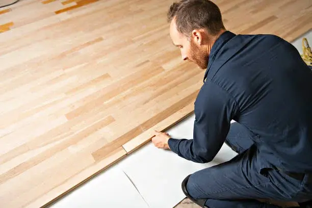 Workers installing wood flooring Workers installing wood flooring