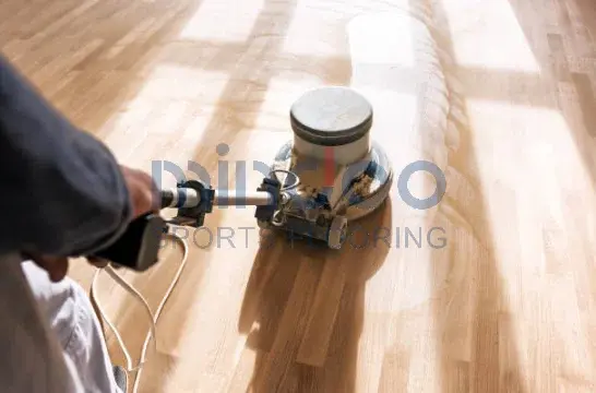 The man is sanding and cleaning the wooden floor. The man is sanding and cleaning the wooden floor.